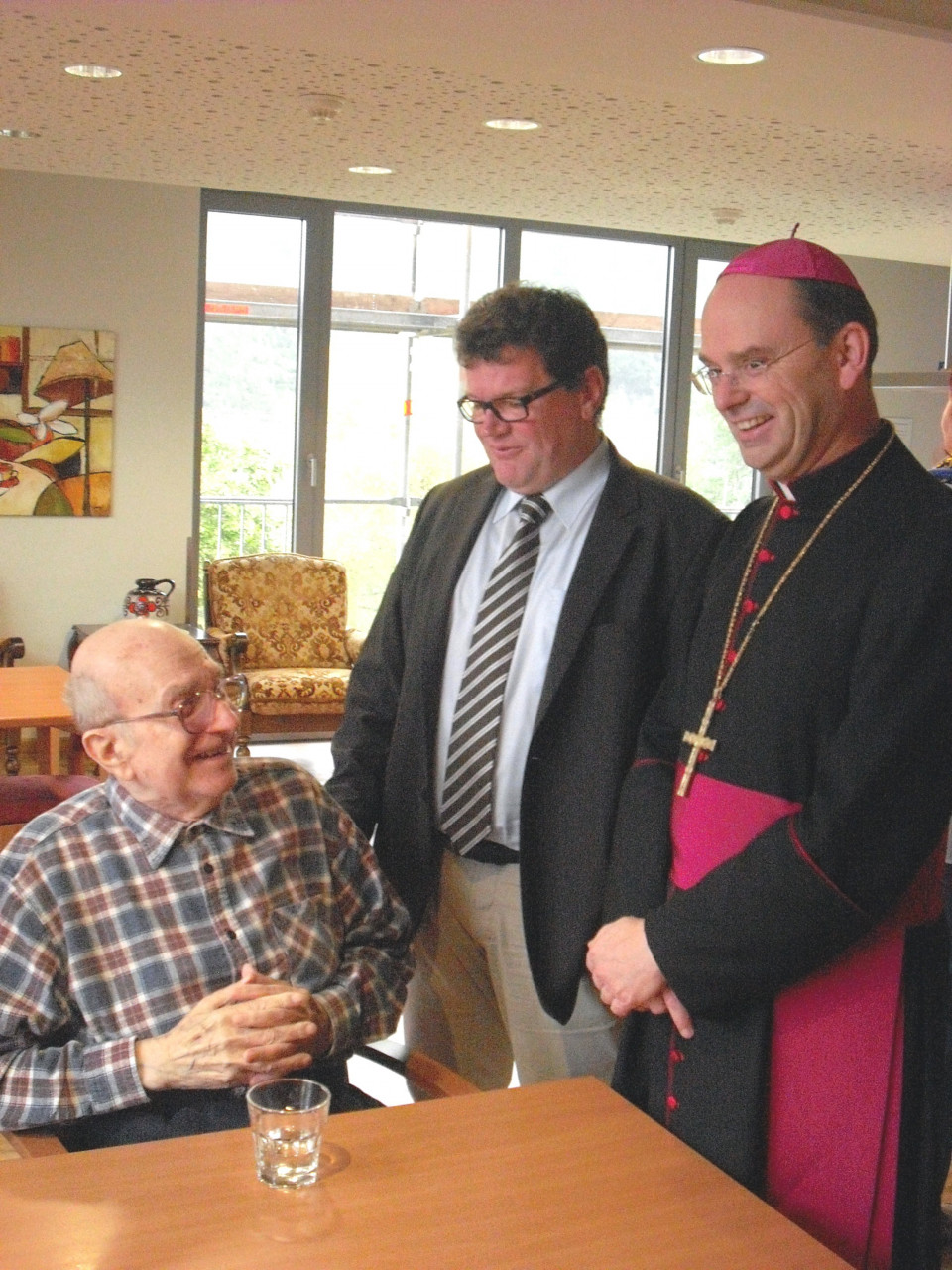 Stephan Manstein und Weihbischof Robert Brahm (rechts) im Gespräch mit einem Bewohner des SeniorenHauses St. Irmina.